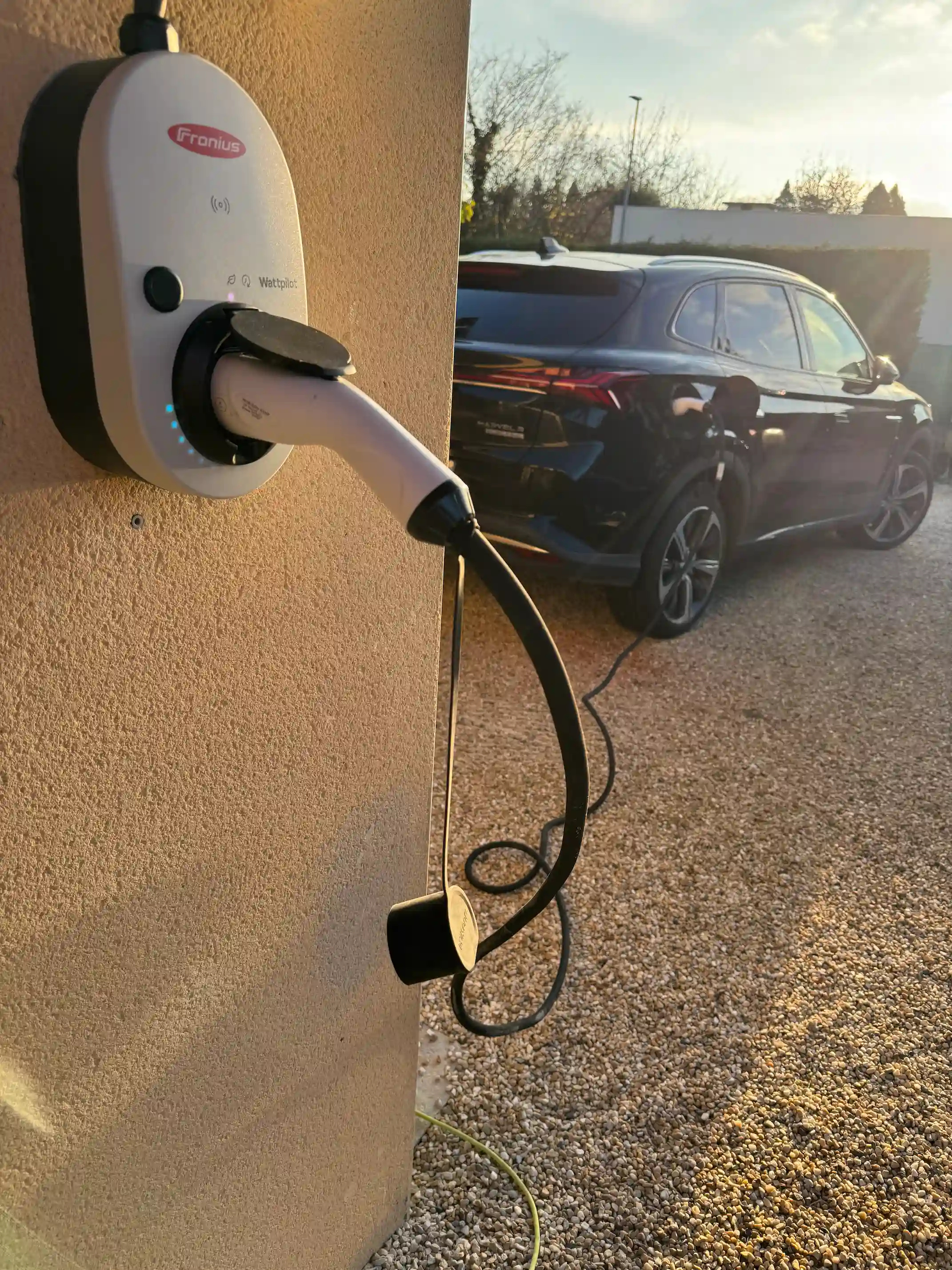 Borne de recharge électrique Photo d'une borne de recharge électrique sur le mur d'une maison